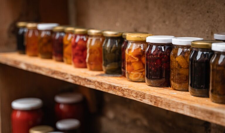 Rafturi de cămară pline cu borcane de zacuscă, murături, dulcețuri și compoturi făcute în casă